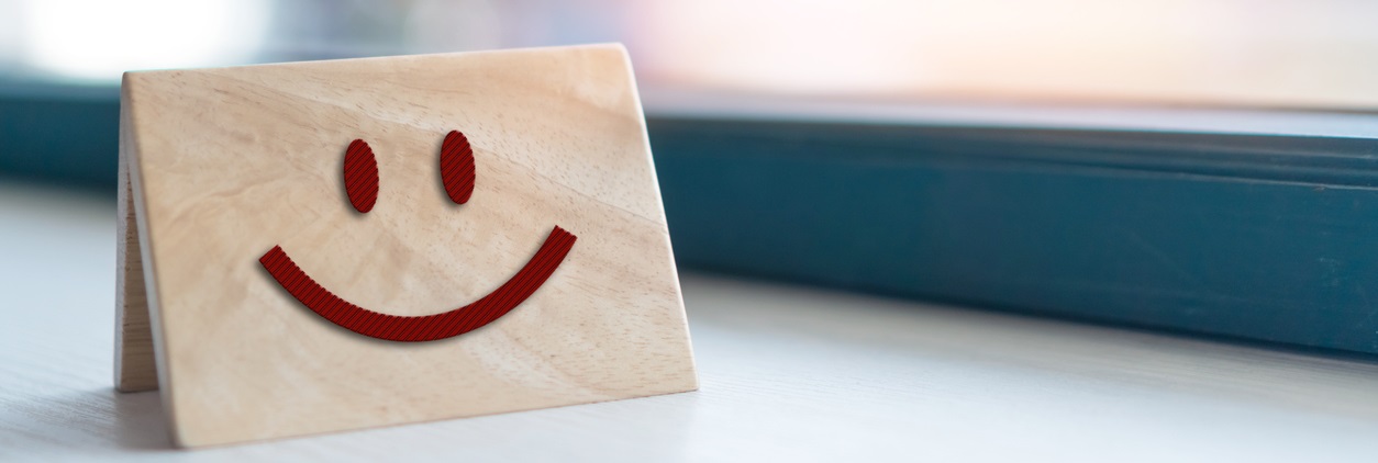 Smiley face icon on wood sign board. Optimistic person or people feeling inside and service rating, satisfaction concept in business.